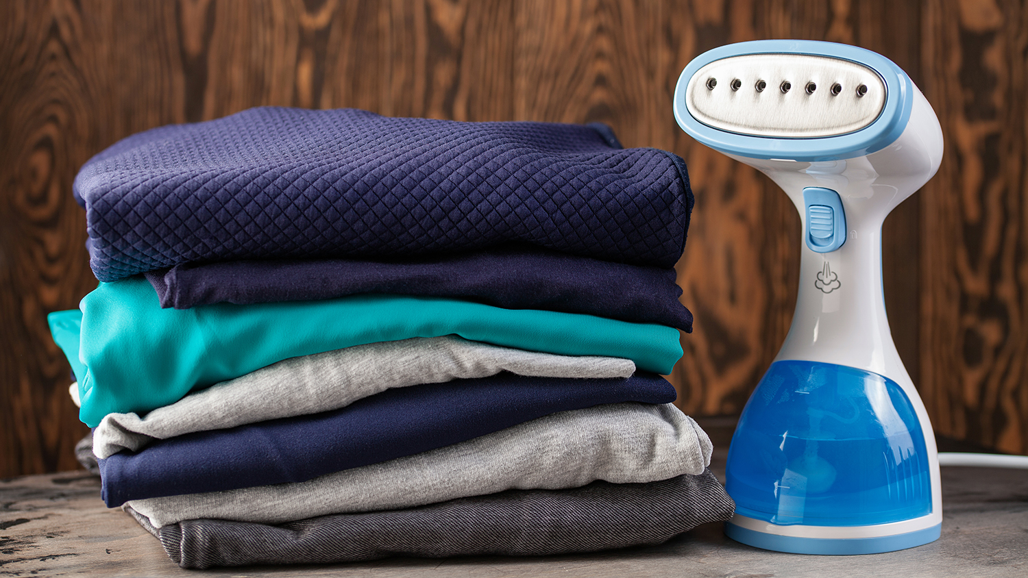 Portable home and travel garment steamer for clothes. Clothes pile. Housework
